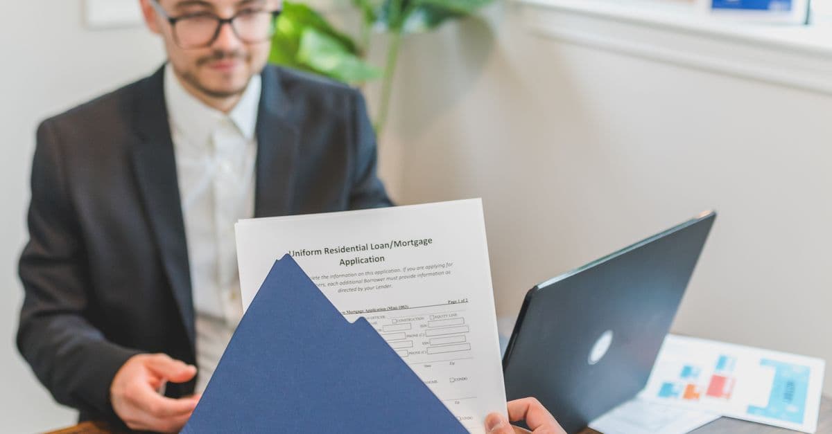 Rådgiver og kunde går gjennom lånepapirer, refinansiering av boliglån